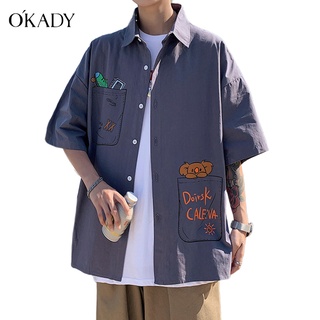 OKADY ฤดูร้อนใหม่เสื้อคู่ผู้ชายลายการ์ตูนแนวโน้มทุกการแข่งขันสวมเสื้อเกาหลีหลวม