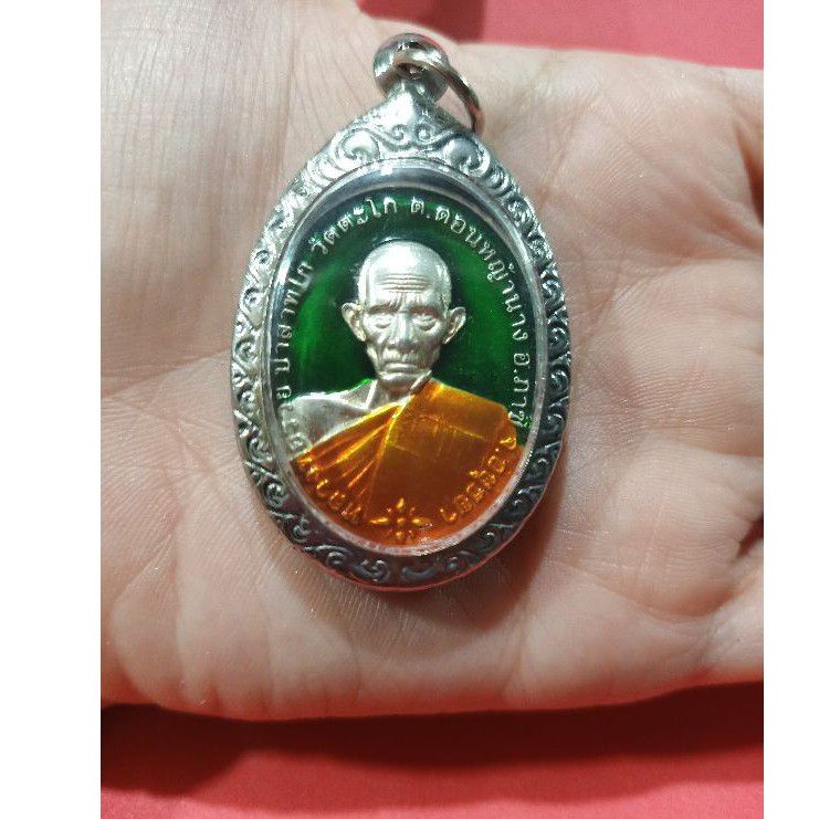 หลวงพ่อรวย เลสหลวงพ่อรวย เหรียญหลวงพ่อรวยเนื้อกะไล่เงินลงยารุ่นชนะจนปี2556เลี่ยมกรอบสแตนเลสแะลายไทย