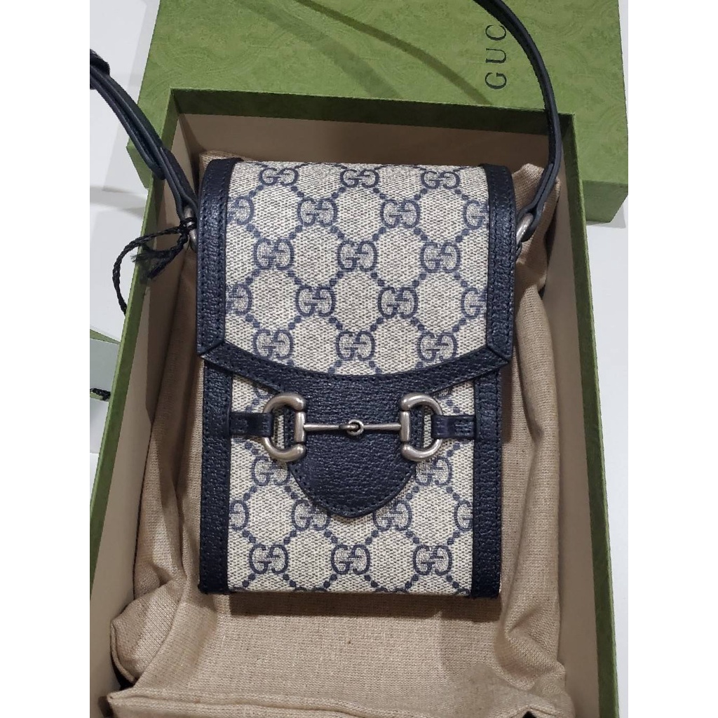 กระเป๋าสะพายใบเล็ก ผ้าใบ GG สีเบจและกรมท่า Gucci Horsebit 1955 Phone Bag Blue แบรนด์ Gucci