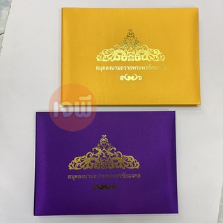 สมุดลงนามถวายพระพรชัยมงคล ปกผ้าตวน สีทอง เเละ สีม่วง ขนาด 22×31ซม. นวน 54 แผ่น ลงนามได้ทั้งหมด 1,500 รายชื่อ