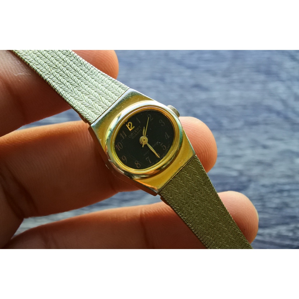 นาฬิกา Vintage มือสองญี่ปุ่น Orient  Quartz ผู้หญิง ทรงกลม กรอบทอง หน้าดำ สายสแตนเลสชุบทอง ใช้งานได้ปกติ สภาพดี ของแท้