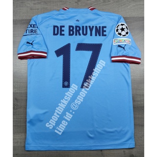 เสื้อฟุตบอล แมนซิตี้ Home เหย้า 2022/23 พร้อมเบอร์ชื่อ 17 DE BRIUNE และอาร์มยูฟ่าแชมป์เปี้ยนลีค