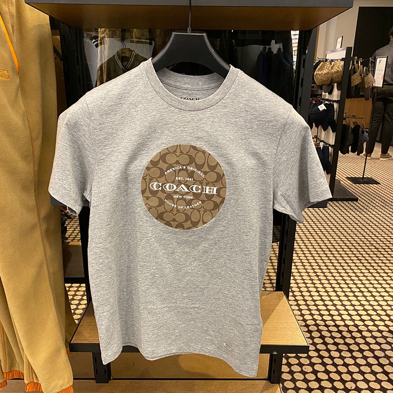 Coach ใหม่ เสื้อยืดลําลอง แขนสั้น คอกลม พิมพ์ลายกราฟฟิคโลโก้ สําหรับผู้ชาย