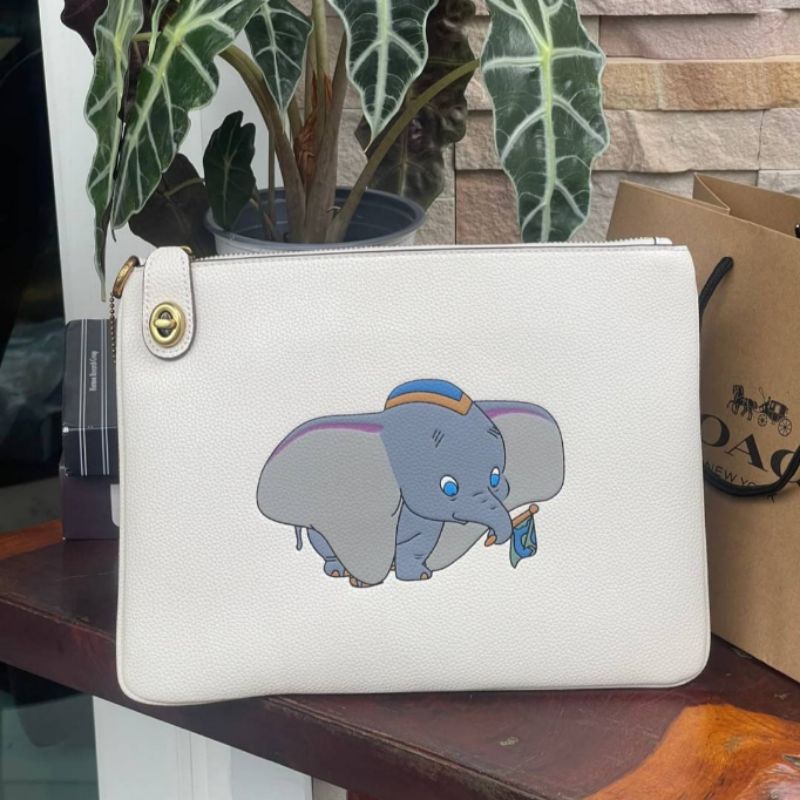 ส่งฟรี🔥 กระเป๋าทรงคลัทช์ แฟ้ม Coach แท้💯 Disney ดัมโบ้ Dumbo สีขาว น่ารัก ใส่ มินิไอแพด ได้  สาวออฟฟิศ ใช้ทำงาน