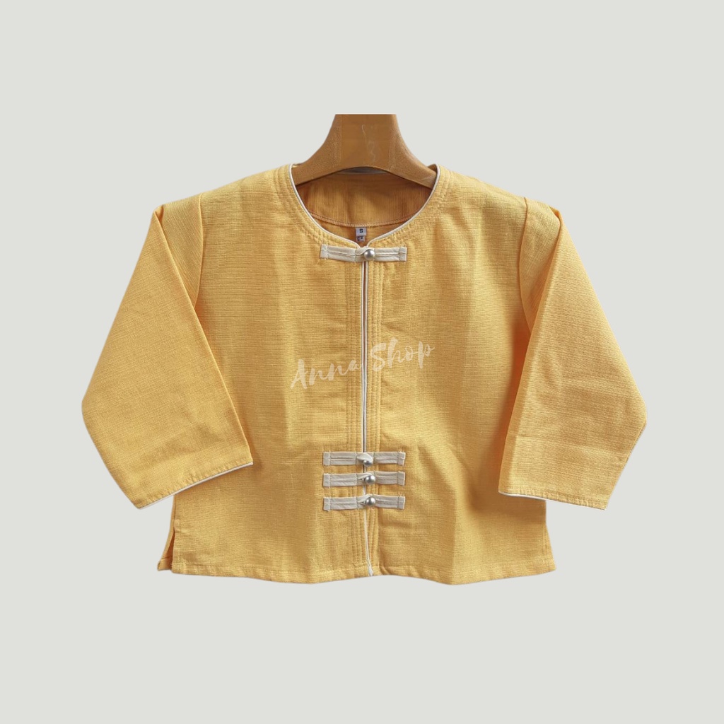 เสื้อผ้าฝ้าย คอกลมผ่าหน้ากระดุมสีเงิน งานกุ้นได้รอบคอและปลายแขน งานโดดเด่นเป็นเอกลักษณ์ สวมใส่ได้ทุกยุคสมัย ตามแบบล้านนา