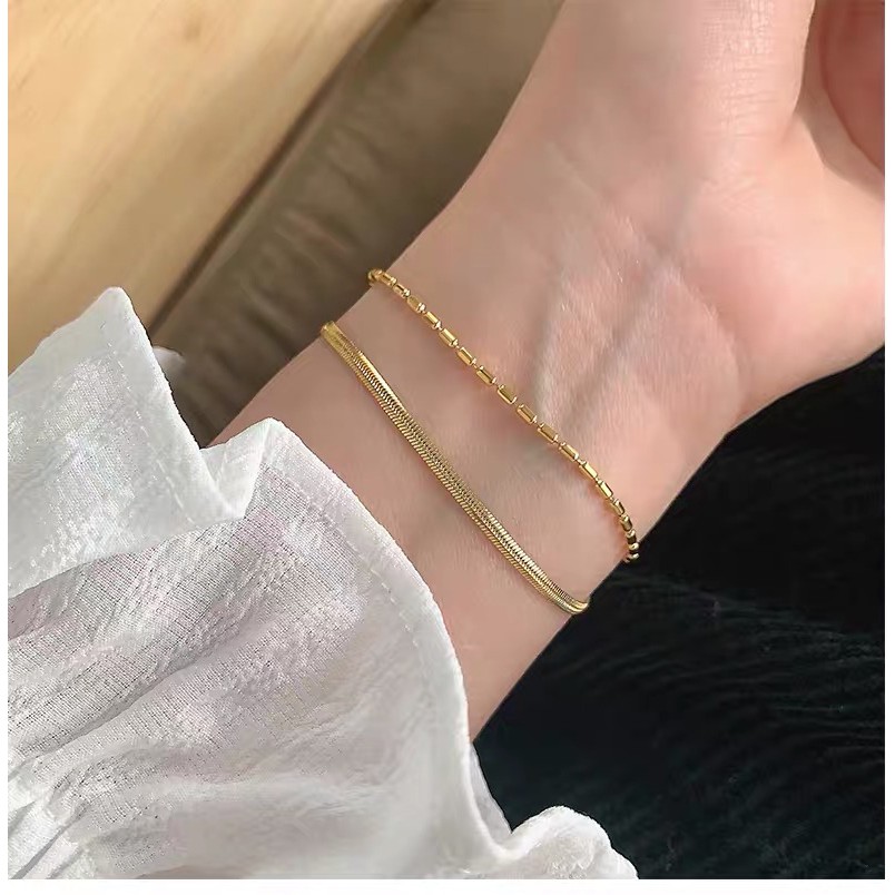 สร้อยข้อมือสองชั้น ไทเทเนียมและเหล็กชุบทอง ออกแบบเรียบหรู สำหรับสวมใส่ทุกวันและเหมาะสมกับทุกกิจกรรม