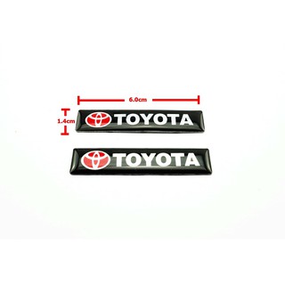 2ชิ้นป้ายโลโก้เลซิ่น TOYOTA พื้นดำตัวหนังสือขาวขนาด 6.0x1.4cm ติดตั้งด้วยเทปกาวสองหน้าด้านหลัง