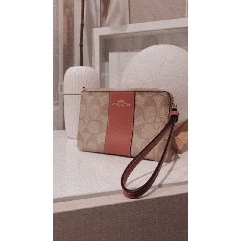 COACH กระเป๋าคล้องมือ Corner Zip Wristlet in Signature Coated Canvas with Leather Stripe รุ่น F58035