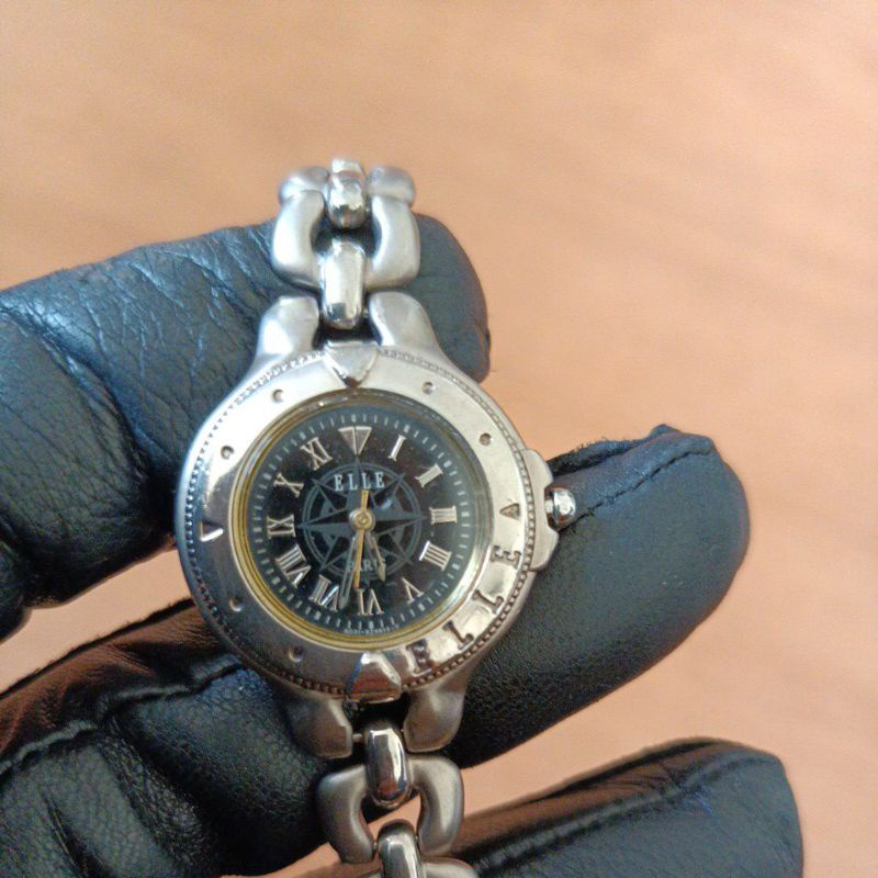 นาฬิกาแบรนด์เนมELLE PARISหน้าปัดสีดำ ตัวเรือนสีเงินสายสแตนเลสสีเทาดำ ของแท้ 100% มือสองสภาพใช้งานได้ปกติ