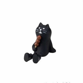 Sitting black cat holding food figure.