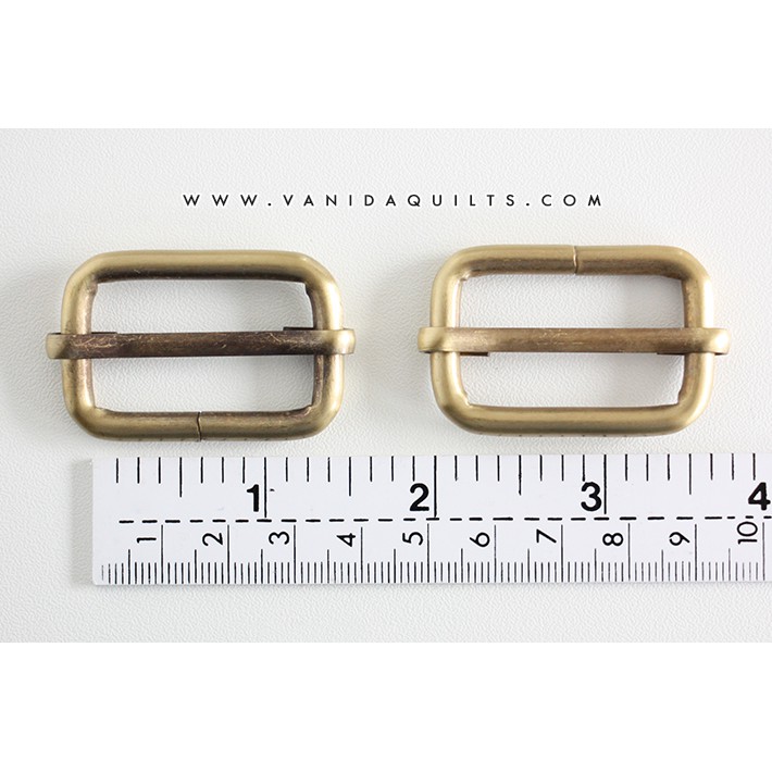 ห่วงสี่เหลี่ยม สำหรับเลื่อนปรับระดับสาย ที่กั้นแบบเลื่อนขอบกลมสีทองเหลืองปัดดำ ขนาด 1+1/4 นิ้ว แพคละ 4 ชิ้น(รหัสjuf0006)