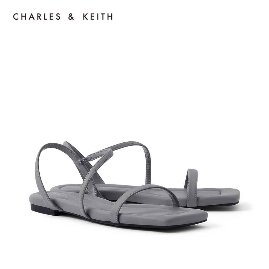 แฟชั่น CHARLES &amp; KEITH2021 ฤดูใบไม้ผลิสินค้าใหม่ CK1-70050127 ผู้หญิงสายรัดแนวทแยงรองเท้าแตะส้นแบนแบบเหลี่ยม