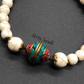 ข้อมือหินฮาวไลท์{Howlite) กลางหินเนปาล สายขนาด6มิล ขนาบข้างหินปาลด้วยขนาด 8มิล ถักเชือกเทียน ความยาว7.5นิ้ว