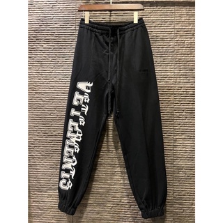 VETEMENTS LOGO-PRINT JOGGERS กางเกงวอร์มขายาว เอวยางยืด ขาจั๊ม กางเกงจ็อกเกอร์ แบรนด์เวตมองต์ส สีดำ สกรีนตัวหนังสือสีขาว