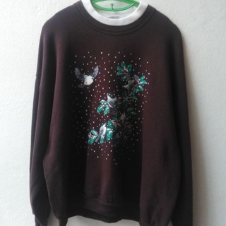 เสื้อกันหนาวแขนยาวสีนำ้ตาล  รอบคอกุ้นด้วยสีขาวครีมตัวเสื้อตกแต่งสกรีนลายนกอยู่นต้นไม้สวยงามน่าสวมใส