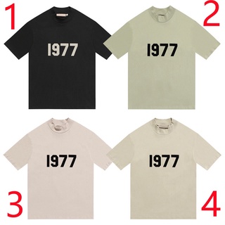 เสื้อยืดแขนสั้นลําลอง ผ้าฝ้าย พิมพ์ลาย ESSENTIALS Flocked 1977 แฟชั่นคู่รัก สไตล์คลาสสิก สําหรับผู้ชาย และผู้หญิง