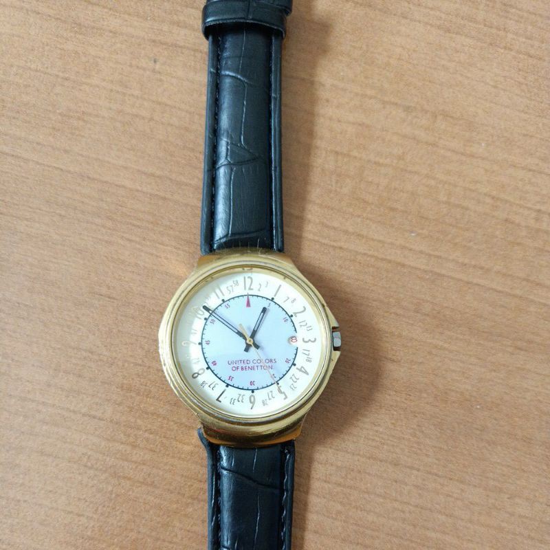 นาฬิกาแบรนด์เนมUNITED COLORS OF BENETTONหน้าปัดสีทอง ช่องวันที่ ตัวเรือนสีทอง สายหนังสีดำของแท้มือสองสภาพสวย
