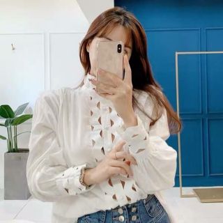 เสื้อเชิ๊ตคอสูง แขนยาว แต่งผ้าลูกไม้ ดีเทลแขนพองนิดๆ ชายสั้นหน้า-ยาวหลัง ทรงปล่อยผ้าใส่สบาย สไตล์แพงเว่อร์
