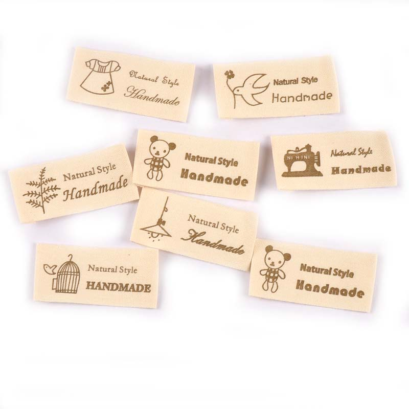 50 ชิ้น/ล็อตผสมพิมพ์การ์ตูน Beige ผ้าฝ้ายทอป้ายสําหรับ Diy เย็บหัตถกรรมเสื้อผ้า Care ป้ายล้างทําความสะอาดได้แท็กเสื้อผ้า CP2441