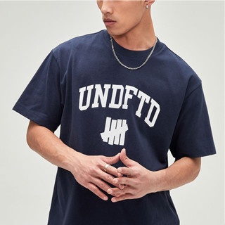 Undefeated เสื้อยืดแขนสั้นลําลอง ผ้าฝ้ายแท้ พิมพ์ลายโลโก้ตัวอักษร สําหรับผู้ชาย และผู้หญิง