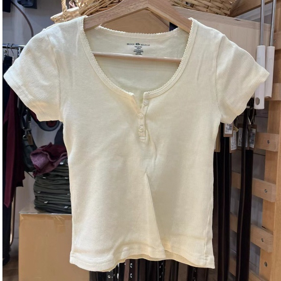 BM สไตล์ครีมคลื่นสีเหลืองลูกไม้สามปุ่มรอบคอแขนสั้นผู้หญิงเอวสูง U คอสีทึบแขนสั้นเสื้อยืดผู้หญิง zell