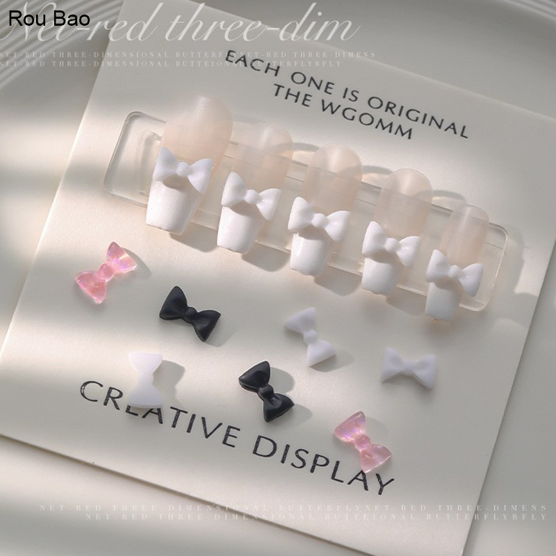 Rou Bao อุปกรณ์ตกแต่งเล็บเรซิ่น รูปโบว์ สีชมพู สีดํา สีขาว สําหรับตกแต่งเล็บ DIY 100 ชิ้น