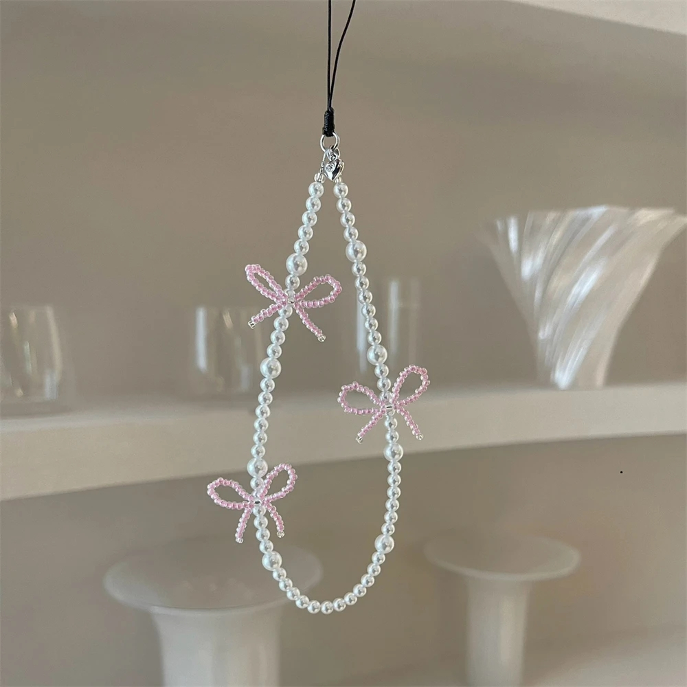 เกาหลีน่ารักสีชมพู Bowknot Pearl จี้ลูกปัดโทรศัพท์ Charm สําหรับ iPhone Accessrioes เชือกเส้นเล็กผู้หญิงสาวเครื่องประดับแขวนเชือกสายคล้อง