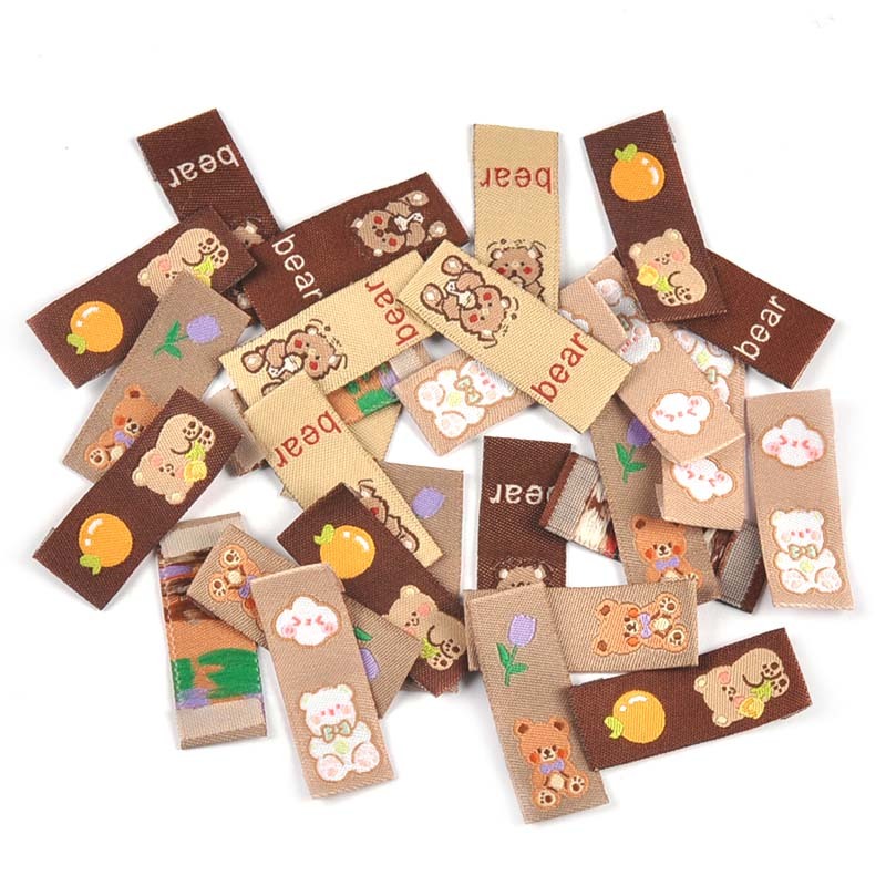50 ชิ้น 40x15 มิลลิเมตรน่ารักสีน้ําตาลล้างทําความสะอาดได้ป้ายสําหรับตัดเย็บเสื้อผ้าอุปกรณ์ DIY หัตถกรรมเสื้อผ้า BagTag Handmade อุปกรณ์ Handwork Decor CP3577
