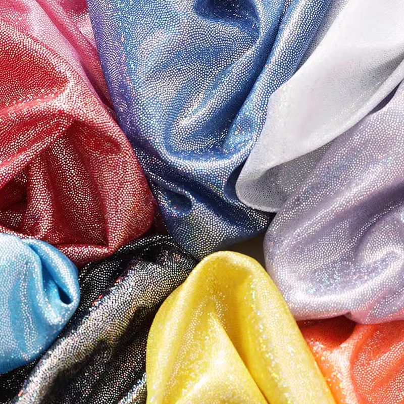 เลเซอร์ Glitter ผ้าที่มีสีสันเงา Bronzing ผ้าเวทีพื้นหลังผ้าเครื่องแต่งกาย DIY เย็บ 1 เมตร TJ0388