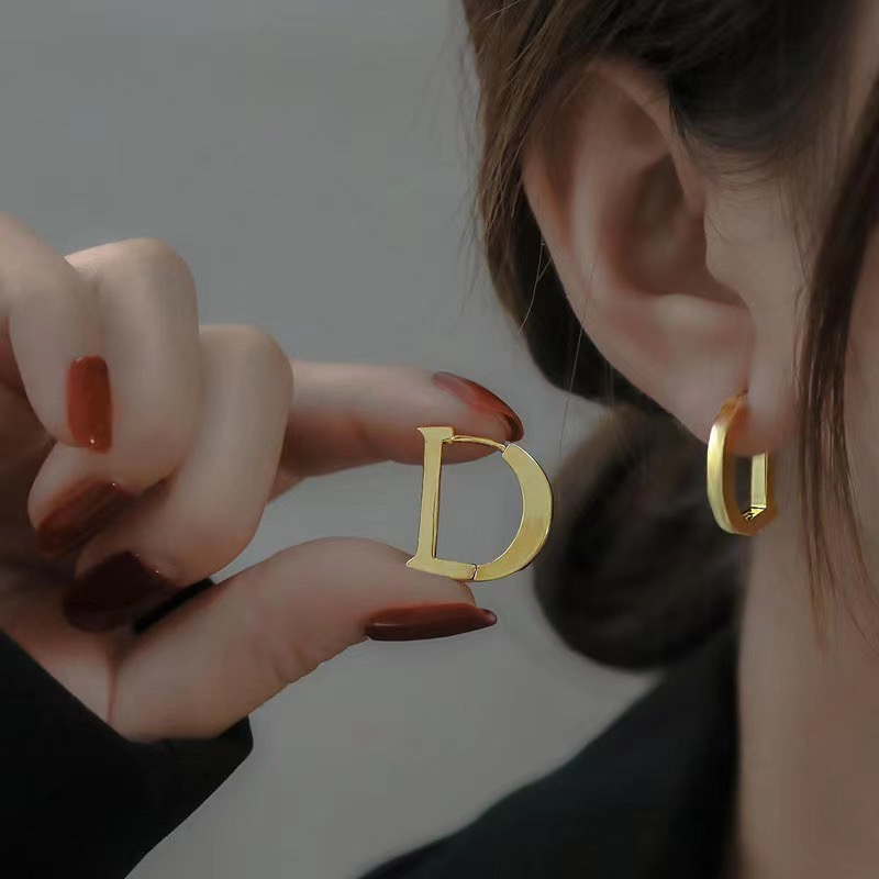 คลาสสิก All-Match สไตล์ตัวอักษร D18K Gold ไทเทเนียมต่างหูเหล็กสี Retention Hypoallergenic หูหัวเข็มขัด