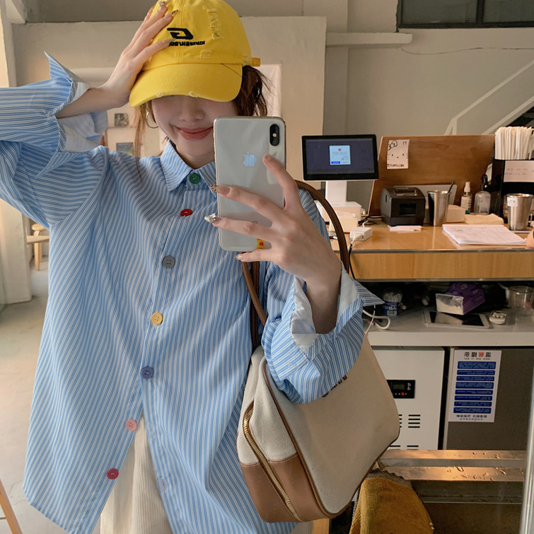 เสื้อเชิ้ตแขนยาวลายทางสีน้ำเงินพร้อมกระดุมหลากสีสำหรับผู้หญิง สไตล์หลวมสบาย เหมาะกับฤดูใบไม้ร่วงต้นๆ และป้องกันแสงแดด