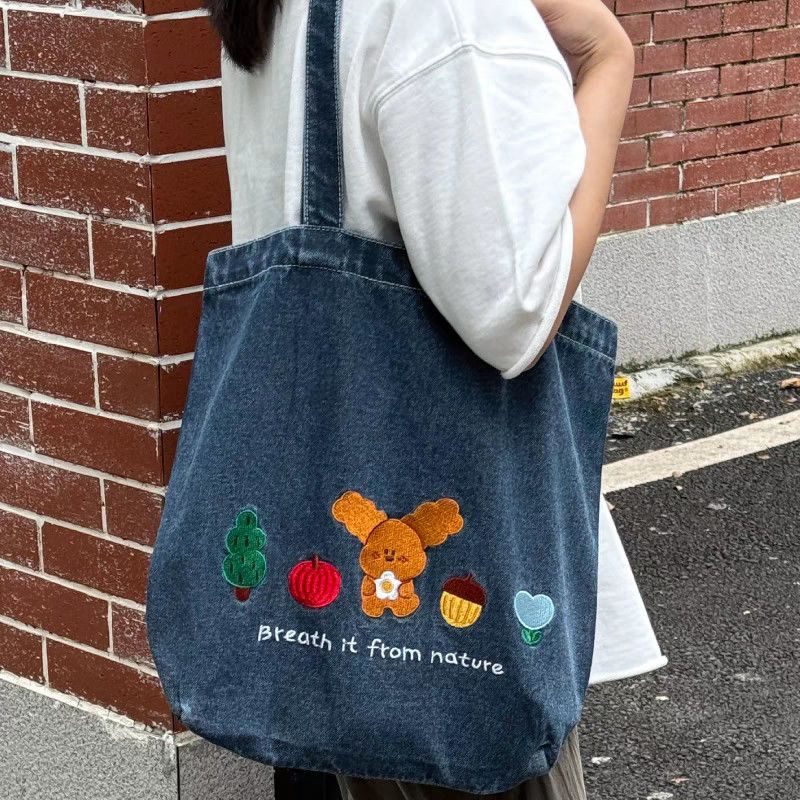 เวอร์ชั่นเกาหลีที่เรียบง่ายและน่ารักลูกสุนัขเย็บปักถักร้อยกระเป๋าผ้าใบยีนส์ย้อนยุคแฟชั่นผู้หญิงนักเรียนสไตล์ลําลองทุกวันสื่อสารความจุขนาดใ