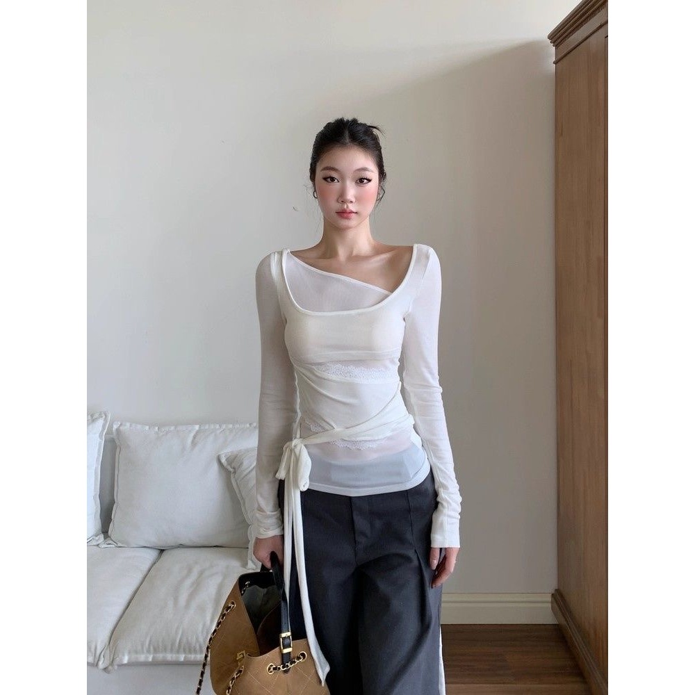 เสื้อยืดแขนยาวสไตล์ซlim-fitสีขาว มีรายละเอียดยกกระชับเล็กน้อย เหมาะสำหรับฤดูใบไม้ร่วง