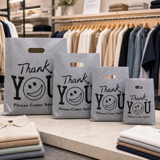 100 ใบ ถุงพลาสติกหูหิ้วลายหน้ายิ้มสีดำ THANK YOU แบบหนาและทนทาน เป็นมิตรต่อสิ่งแวดล้อม เหมาะสำหรับใส่ของขวัญ เสื้อผ้า และสินค้า พกพาได้สะดวก หูหิ้วแข็งแรง ช่วยจัดของให้เป็นระเบียบ เหมาะสำหรับร้านค้า การช้อปปิ้ง และใช้งานประจำวัน ใส่ของง่าย ถือสะดวกทุกวัน