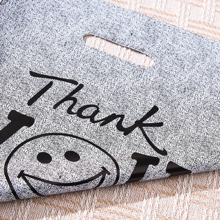 100 ใบ ถุงพลาสติกหูหิ้วลายหน้ายิ้มสีดำ THANK YOU แบบหนาและทนทาน เหมาะสำหรับใส่เสื้อผ้า ของขวัญ และสินค้า พกพาสะดวก หูหิ้วแข็งแรง ช่วยจัดของให้เป็นระเบียบ ใช้งานง่าย เหมาะสำหรับร้านค้า บูติก และการช้อปปิ้งในชีวิตประจำวัน เหมาะสำหรับการใช้งานทั่วไปในทุกวัน
