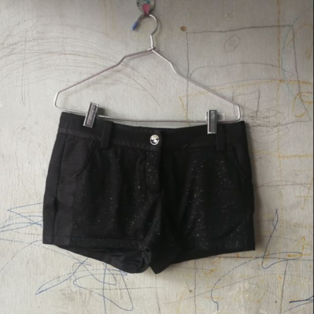 กางเกงขาสั้นสีดำ​ ข้างหน้าเป็นลายเลื่อมๆ​ ของ​ XACT