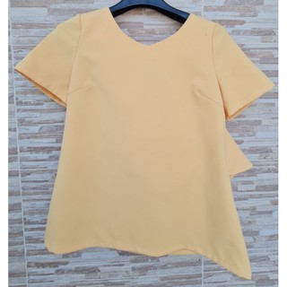 เสื้อสีเหลืองคอกลมผ้าอัดกาว ด้านหลังมีช่วงเว้า มีระะบาย