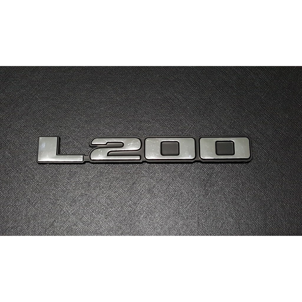 Best saller 1ชิ้น L200 LOGO แผ่นป้ายติดข้างรถกระบะมิตซูบิชิ ทุกรุ่น สีชุบขอบดำ MITSUBISHI STRADA TRITON CYCLONE โลโก้ STICKER ของแต่งรถ อะไหร่รถ GTR กรอบป้าย กระจก คราฟ โลโก้ LOGO หัวเกียร์