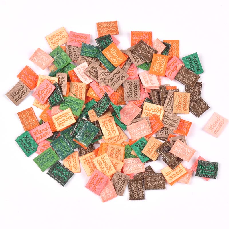 100 ชิ้น/ล็อต 11X15 มม.Multicolor เสื้อผ้าแท็กป้ายทําด้วยมือนูนป้ายสําหรับกระเป๋าเสื้อผ้าการพิมพ์เย็บ DIY อุปกรณ์เสริม CP2393