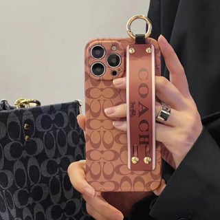 Coach เคสโทรศัพท์มือถือ Tpu แบบนิ่ม กันกระแทก มีสายรัดข้อมือ สําหรับ iPhone 14 13 12 11 Pro Max Plus XS XR X