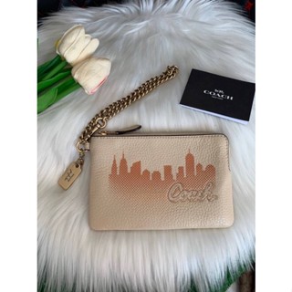 กระเป๋าคล้องมือ 1 ซิป COACH X JENNIFER LOPEZ CORNER ZIP WRISTLET WITH NYC SKYLINE C6514 สี GOLD/CREAM ไซส์ S 6 นิ้ว