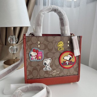 ✅กระเป๋าCoach Coach X Peanuts Dempsey Tote 22 In Signature Canvas With PatchesStyle No. CE851