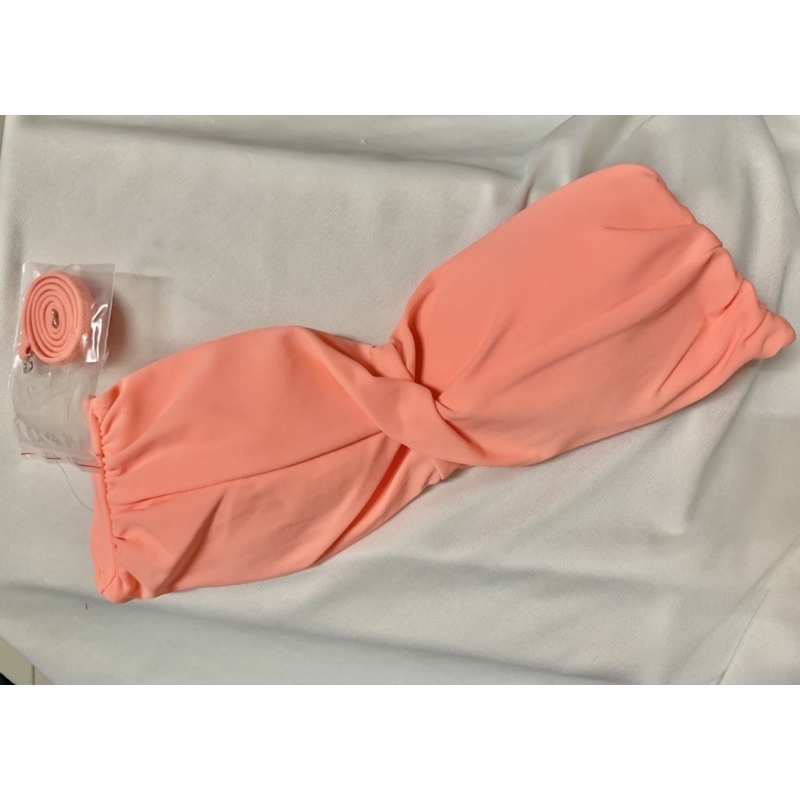 บราเดี่ยวท่อนบนทรงเกาะอกสีส้ม ดีเทลด้านหน้าเป็นทรงมัดใจ มีสายคล้องคอให้