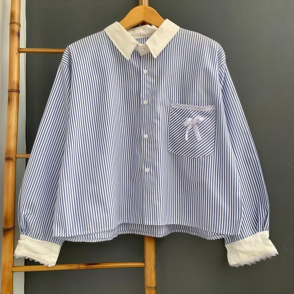 เสื้อเชิ้ตแขนยาวลายทางน่ารักและหวานสําหรับสุภาพสตรีมีแขนเสื้อลูกไม้และดีไซน์ปก มันดูดียิ่งขึ้นเมื่อคู่กับกระโปรงสีพื้น