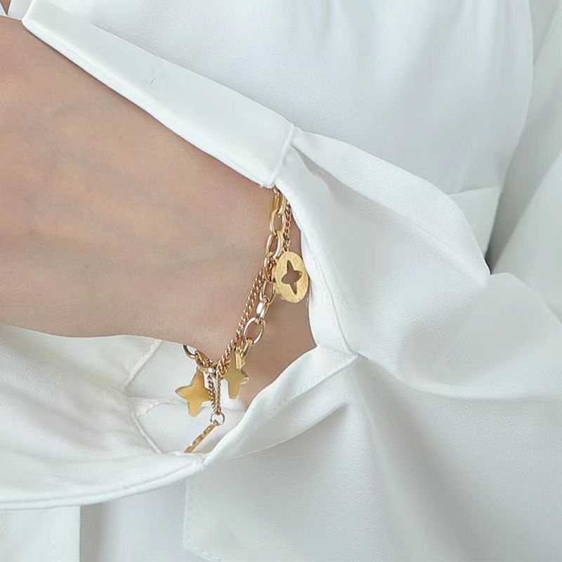 สร้อยข้อมือโซ่เหล็กไทเทเนียม สองชั้น จี้ใบโคลเวอร์สี่แฉก ประดับพู่ ไม่จางหาย สไตล์เกาหลี สําหรับผู้หญิง