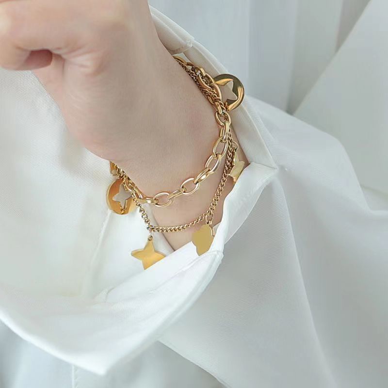 สร้อยข้อมือโซ่เหล็กไทเทเนียม สองชั้น จี้ใบโคลเวอร์สี่แฉก ประดับพู่ ไม่จางหาย สไตล์เกาหลี สําหรับผู้หญิง