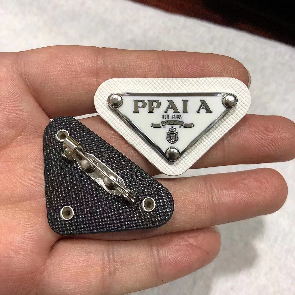 ใหม่ เข็มกลัดโลโก้สามเหลี่ยม โลหะ หนัง เข็มกลัด ผู้ชายและผู้หญิง เสื้อผ้า กระเป๋า