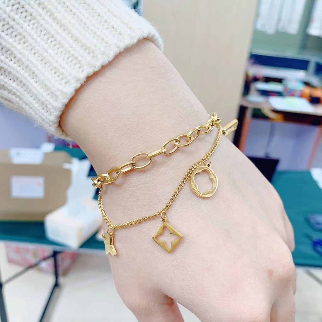 สร้อยข้อมือโซ่เหล็กไทเทเนียม สองชั้น จี้ใบโคลเวอร์สี่แฉก ประดับพู่ ไม่จางหาย สไตล์เกาหลี สําหรับผู้หญิง