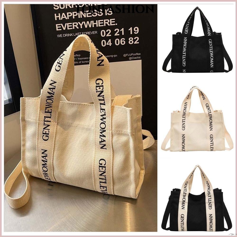 Tonfashion กระเป๋าสะพายไหล่ กระเป๋าถือลําลอง ผ้าแคนวาส ขนาดใหญ่ จุของได้เยอะ ลายตัวอักษร สีดํา แฟชั่นเรียบง่าย สําหรับสตรี 1 ชิ้น
