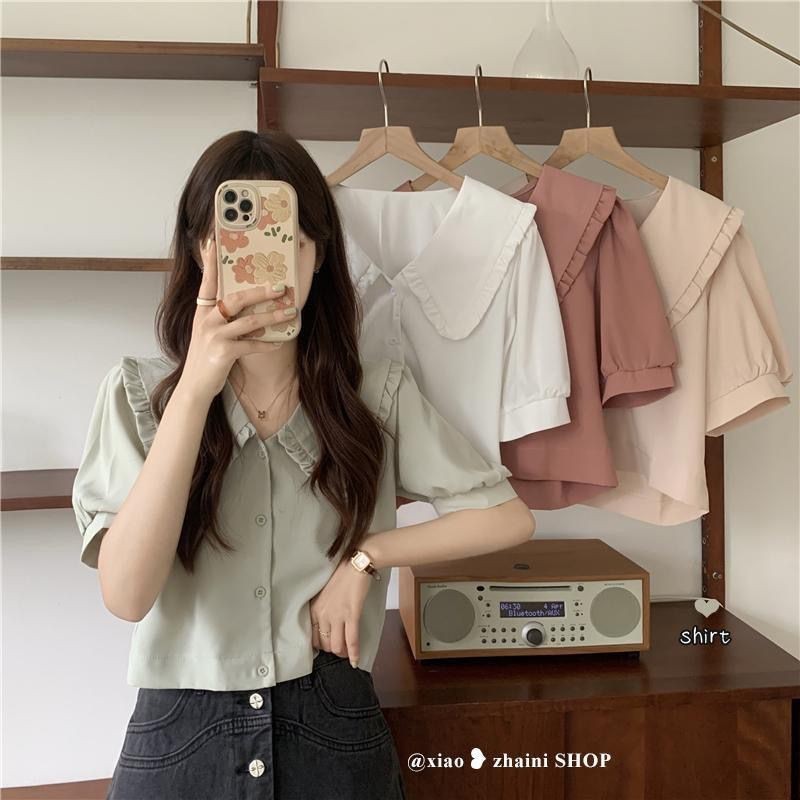 เสื้อเชิ้ตแขนสั้นคอตุ๊กตาสีขาวฝรั่งเศสผู้หญิง 2023 เสื้อเชิ้ตฤดูร้อนสไตล์ใหม่ดีไซน์ซอกเก๋ด้านบน